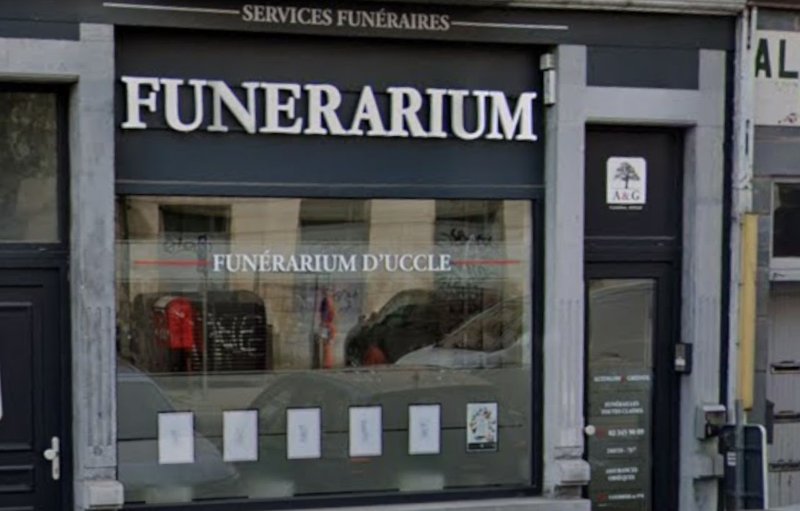 Devanture sombre du Funérarium d’Uccle, grande enseigne « Funerarium » et vitrine donnant sur le hall d’accueil.