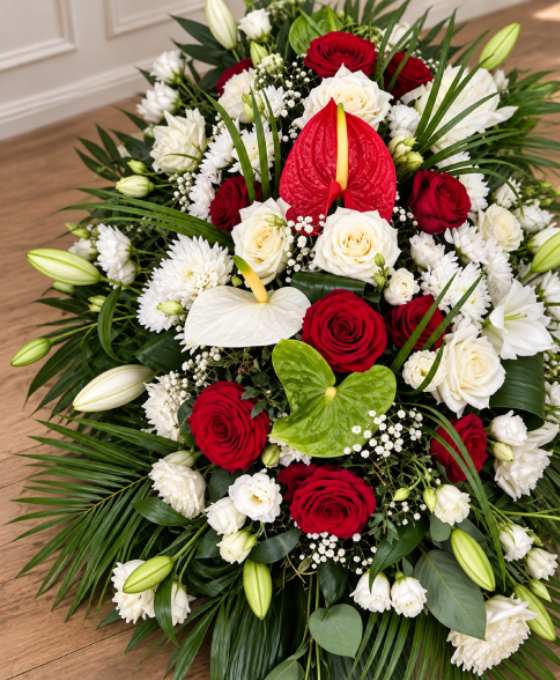 Gros plan : pièce allongée en roses rouges et blanches Gros plan sur les fleurs : pièce allongée en roses rouges et blanches, avec anthuriums et lys