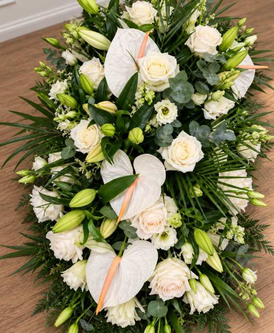 Gros plan : pièce allongée en lys et roses blanches Gros plan sur les fleurs : pièce allongée en lys et roses blanches, avec anthuriums blancs