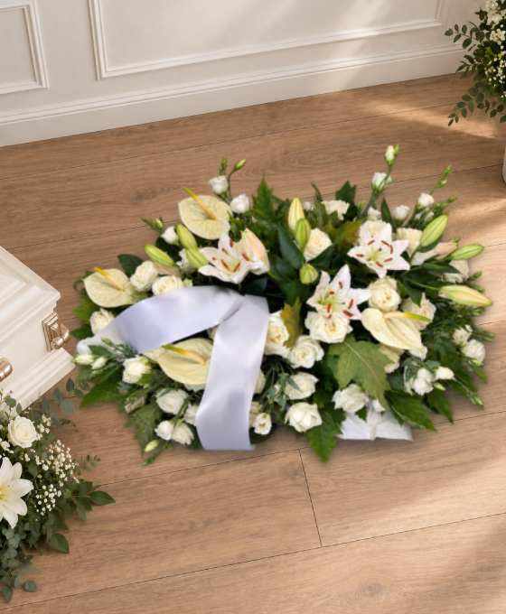 Bûche funéraire tout en blanc, en lys, lisianthus et roses