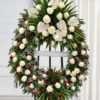 Couronne sur trépied en roses blanches semées Couronne mortuaire blanche et rouge en roses, avec des anthuriums et des palmes, sur trépied