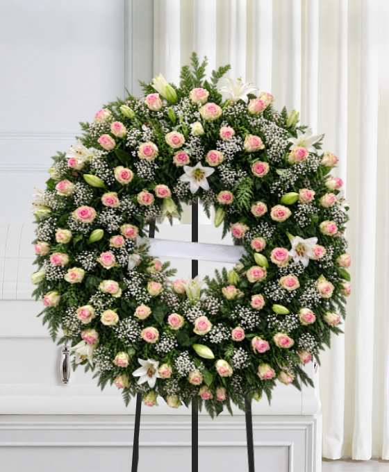 Couronne mortuaire rose et lys blancs, en roses crème avec gypsophile, sur trépied