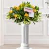 Coussin en roses jaunes Coussin de roses et lys sur colonne, en jaune avec de la verdure et une carte de condoléances