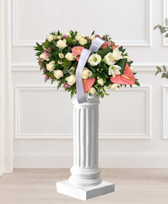 Coussin mortuaire crème et rose en roses et anthuriums, avec des alstroemerias et un ruban