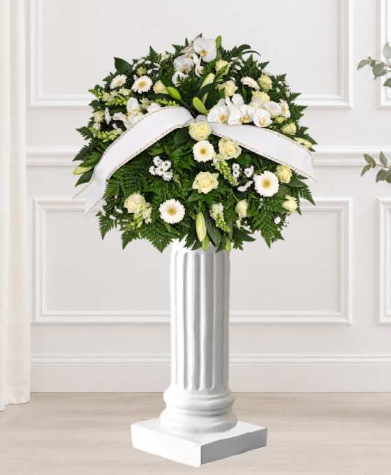 Coussin mortuaire blanc en roses et lys, avec des chrysanthèmes et un ruban blanc
