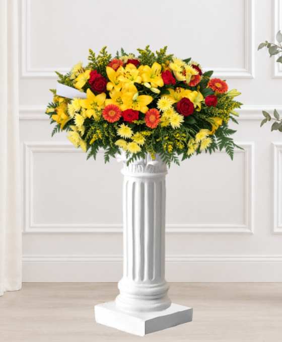 Coussin mortuaire jaune et rouge en lys, gerberas et roses, avec du solidage