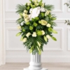 Coussin en lys blancs Coussin mortuaire blanc et vert en lys, roses et chrysanthèmes, avec des palmes et une carte